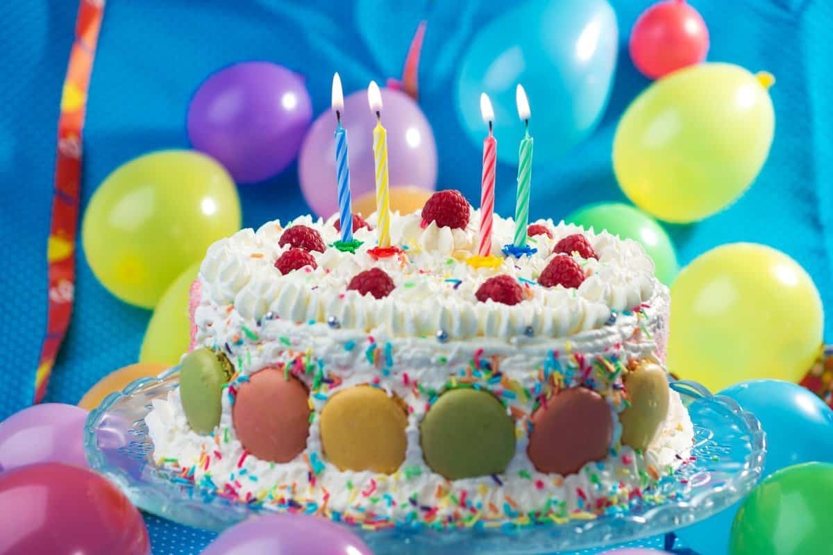 A Birthday Cake With Lit Candles Surrounded By Balloons Stock Photo,  Picture and Royalty Free Image. Image 212005274.